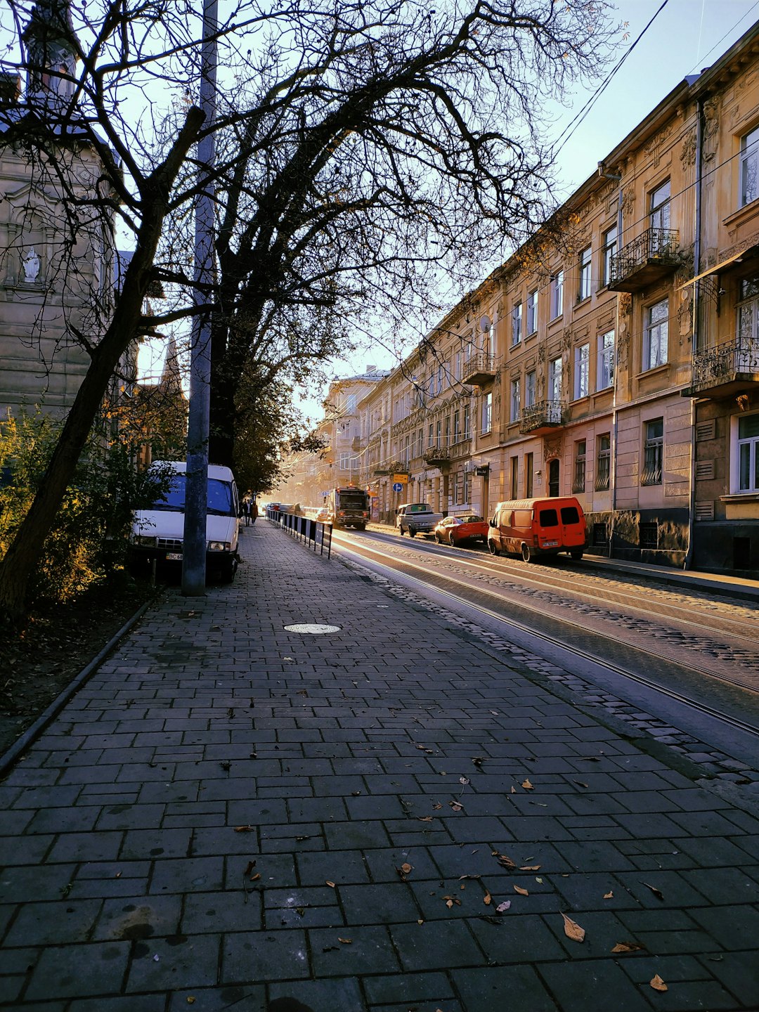 Historic city street with ornate buildings and tram tracks.